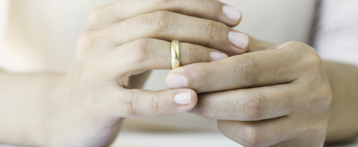 persons hand on their finer taking their gold wedding ring off divorce civardi obiol