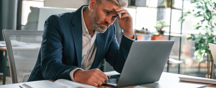 Businessman looking at his computer with a stressed face