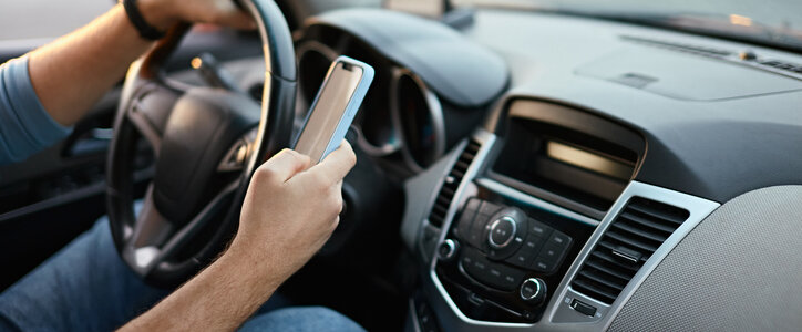 Man driving while texting on the phone.