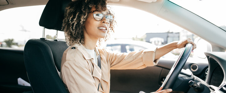 Young woman driving her car during the day.