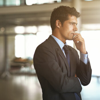 Stressed businessman looking out at his office.